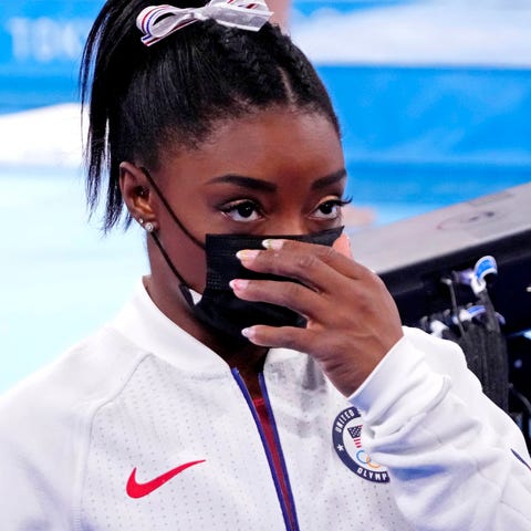 Simone Biles (USA) looks on after pulling out of t