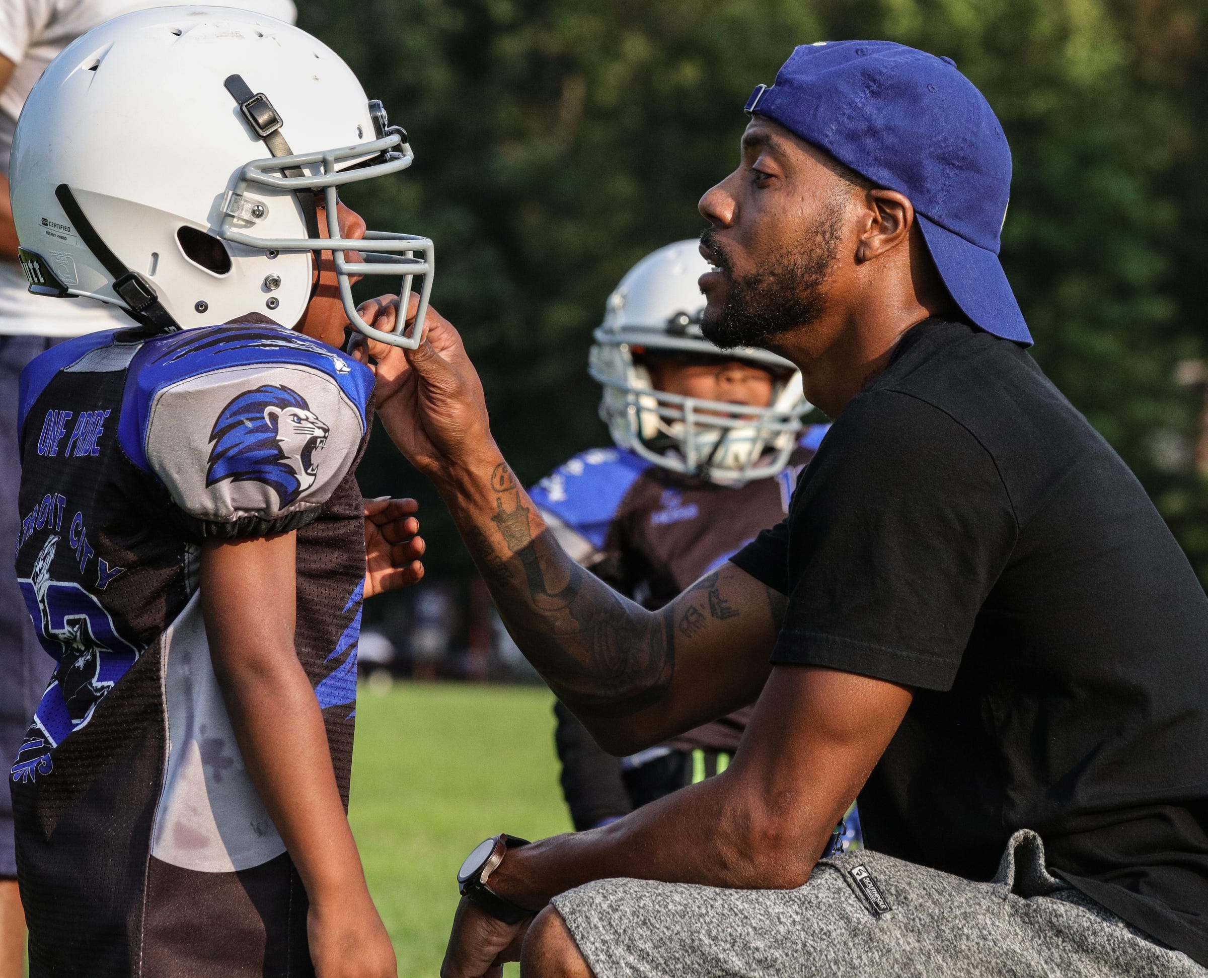 Coach Lorenzo Pearson talks with player during practice  at Marygrove College in Detroit on July 29, 2021. Detroit City Lions, a youth program founded by Devon Buskin is more than a youth football program. The program offers robotics classes, volleyball, musical arts along with football and cheer.