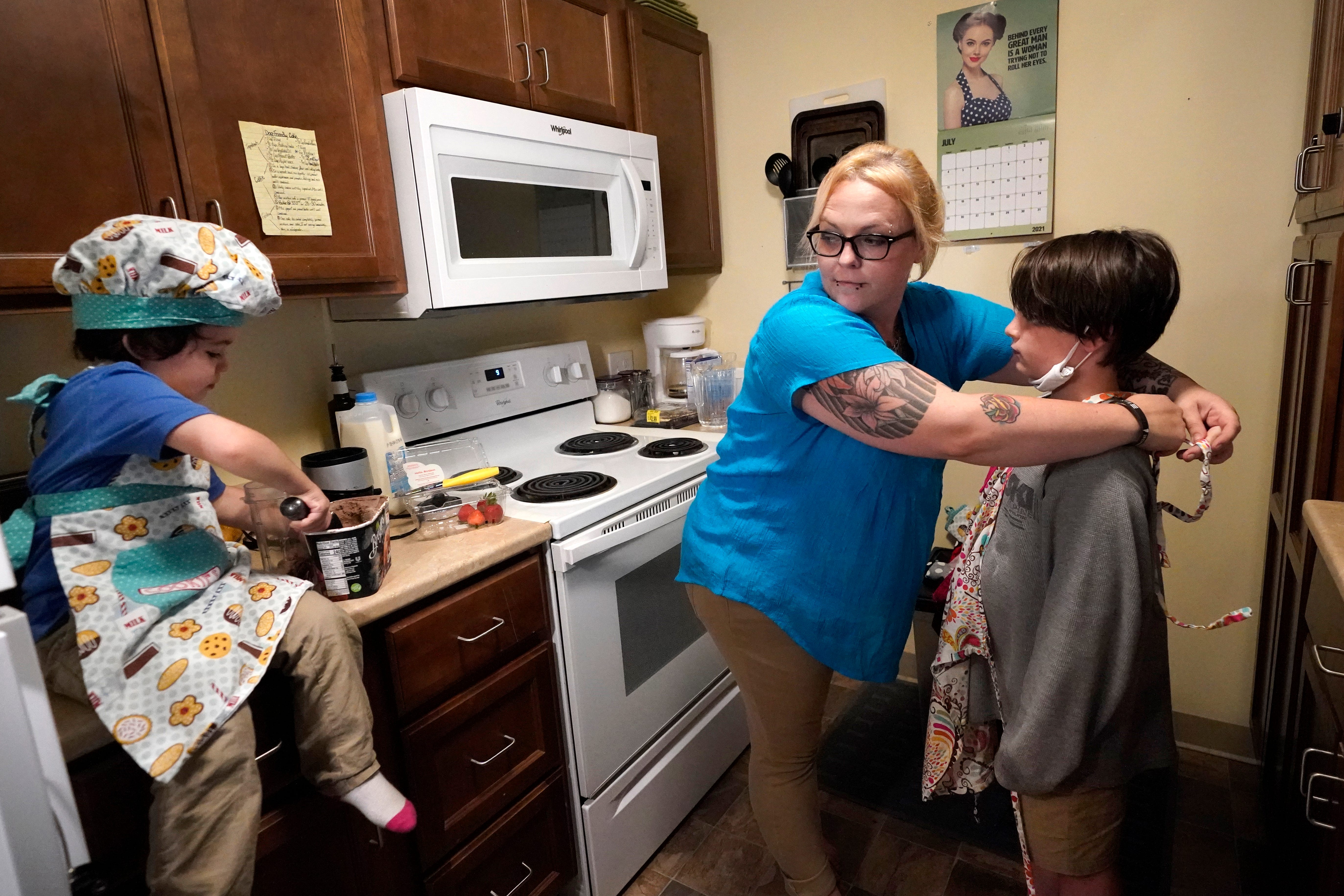In this July 28, 2021 photo, Christina Darling and her sons, Brennan, 4, left, and Kayden, 10, prepare a snack at home in Nashua, N.H. Darling and her family have qualified for the expanded child tax credit, part of President Joe Biden