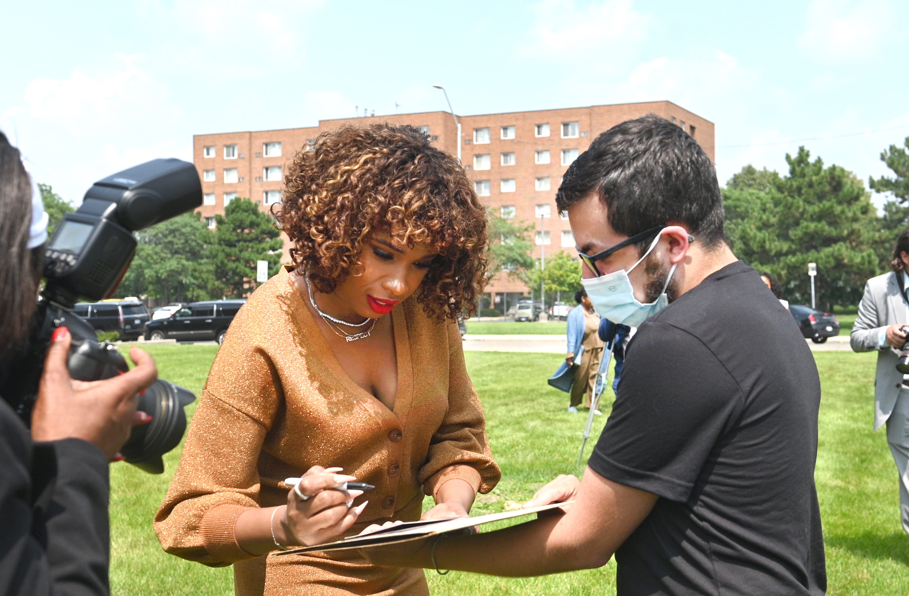Jennifer Hudson (left) signs an autograph for Jacob Matlia outside the Charles Wright Museum's light-up RESPECT letters.