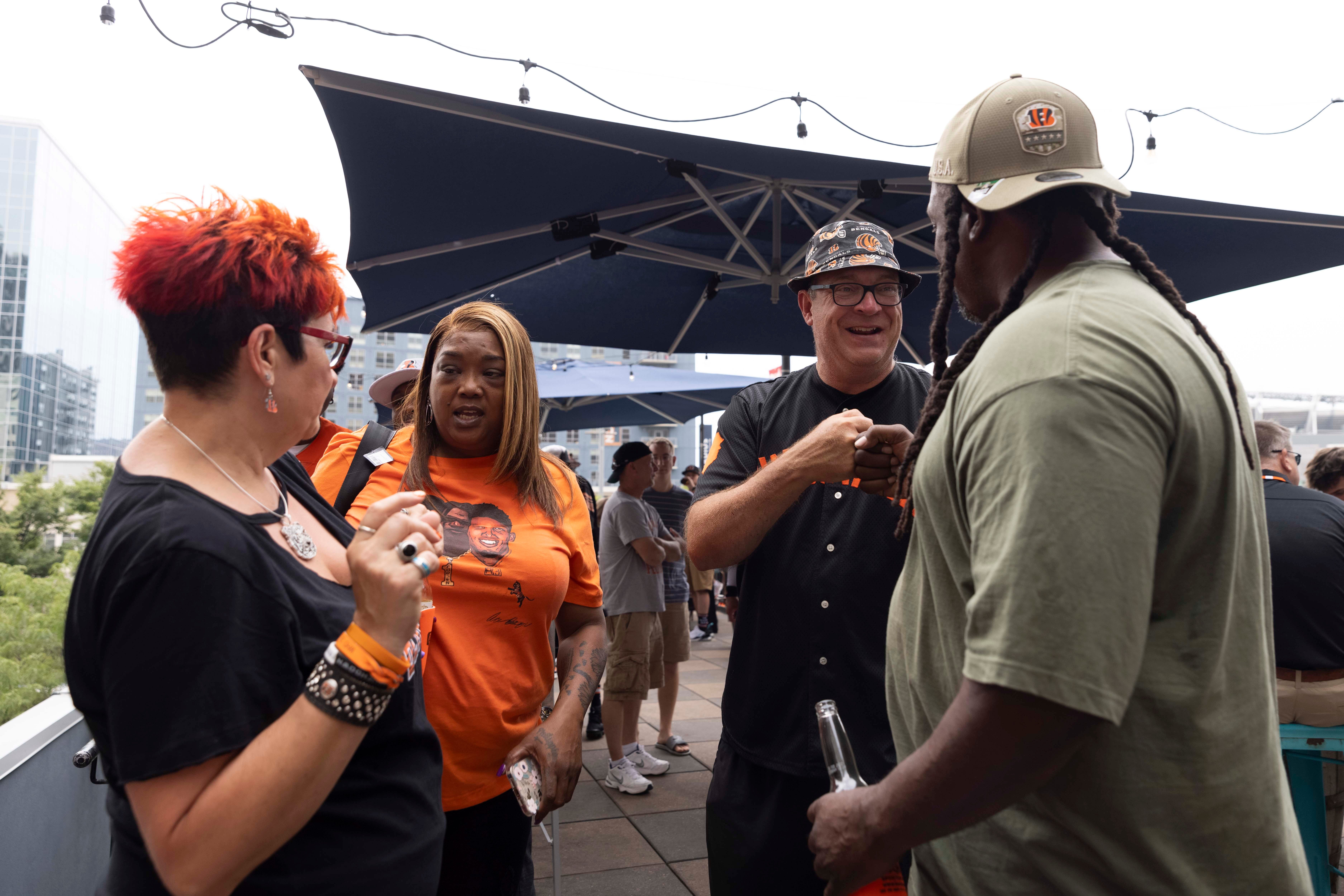 Jim Foster fist bumps Eric Higgins, right, the father of Bengals wide receiver Tee Higgins, at The Blind Pig in Downtown on the day of the Bengals’ Back Together Saturday open practice.