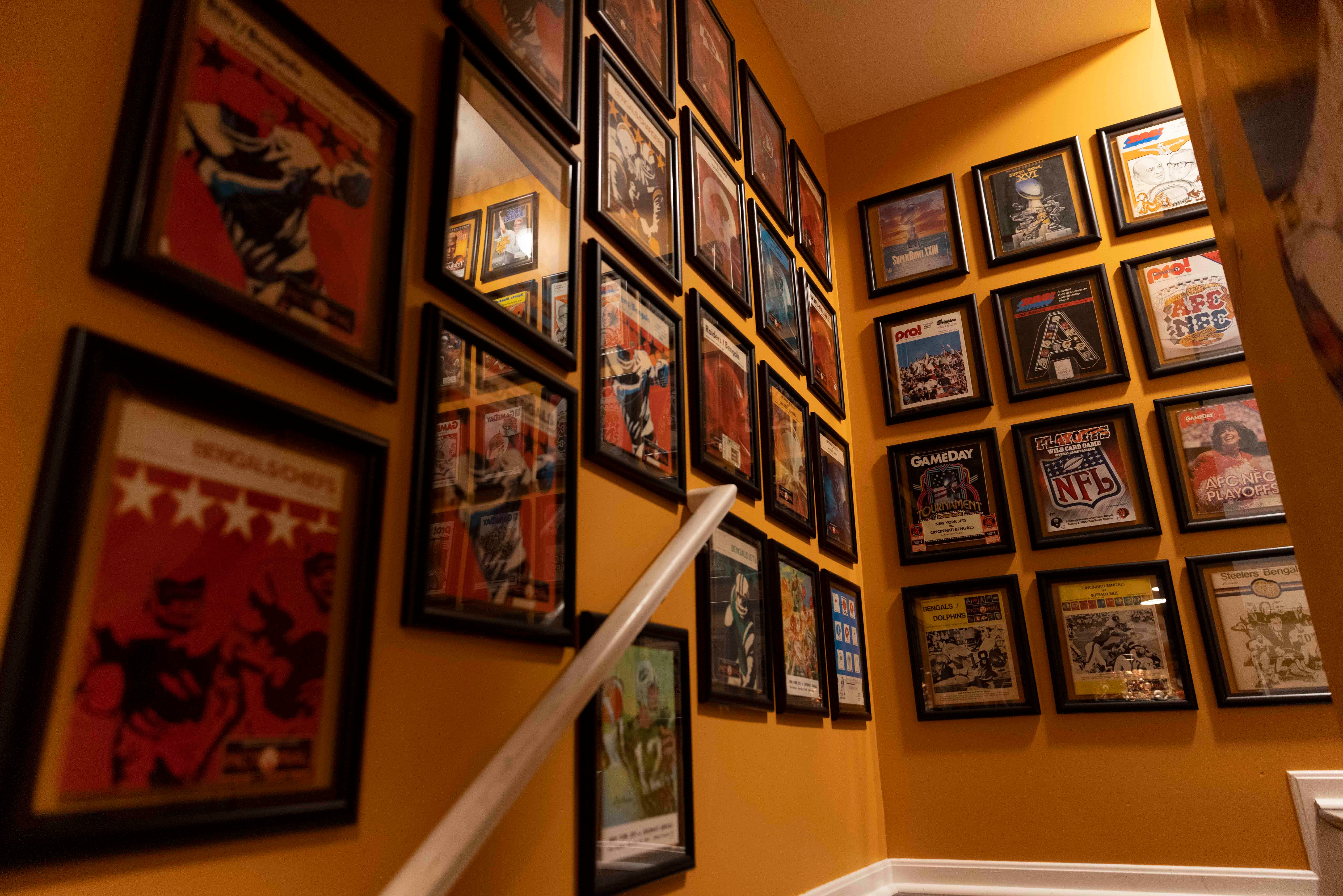 Memorabilia hangs on the walls of the staircase leading to Jim Foster’s basement at his home in Green Township on the day of the Bengals’ Back Together Saturday open practice, Saturday, July 31, 2021, at Paul Brown Stadium in the Downtown neighborhood of Cincinnati, Ohio.Foster, a life-long Bengals fan, has a Bengals YouTube channel, a podcast, a long-running tailgate and a Bengals history museum in his home.