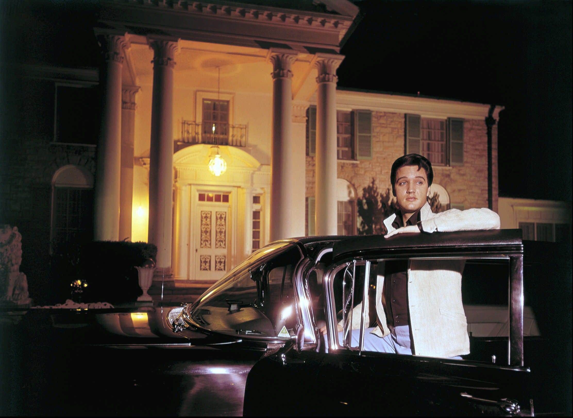 Elvis Presley posed with one of his cars outside Graceland in this photograph published March 7, 1965. Elvis complained of the long sessions with photographers making movie publicity stills: "I try to cut the time down to three or four hours, but sometimes you have to pose for six or eight. A man only has so many different smiles, and I don't have many."