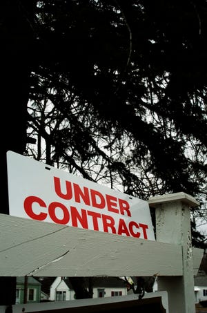 Realtor sign advertises that a home for sale is now under contract.