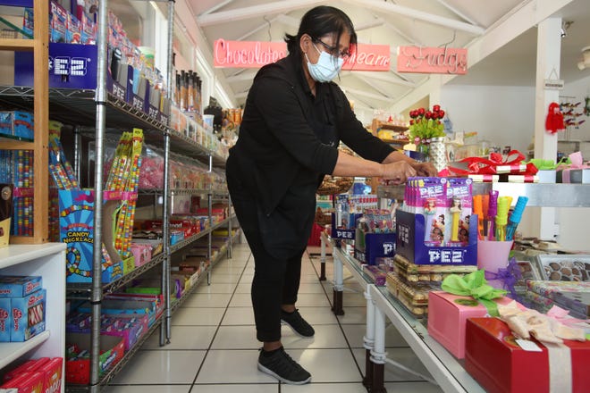 Palm Springs Fudge and Chocolate owner Lutfa Mobarak Norah stocks the shelves in the downtown store in Palm Springs, Calif., on August 3, 2021. 
