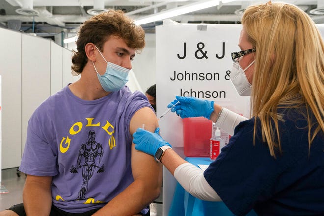 FILE â€” In this July 30, 2021 file photo, Bradley Sharp, of Saratoga, N.Y., gets the Johnson & Johnson vaccine from registered nurse Stephanie Wagner, in New York. Sharp needs the vaccination because it is required by his college. Hundreds of college campuses across the country have told students that they must be fully vaccinated against COVID-19 before classes begin in a matter of weeks. (AP Photo/Mark Lennihan, File)