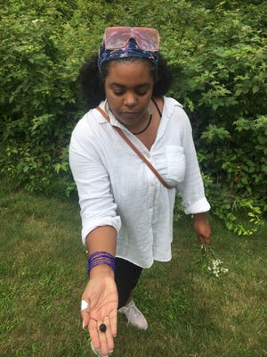 Meclina Gomes, co-founder of the Community Art Collaborative, shows off a blackberry that will be used as dye for the art project.