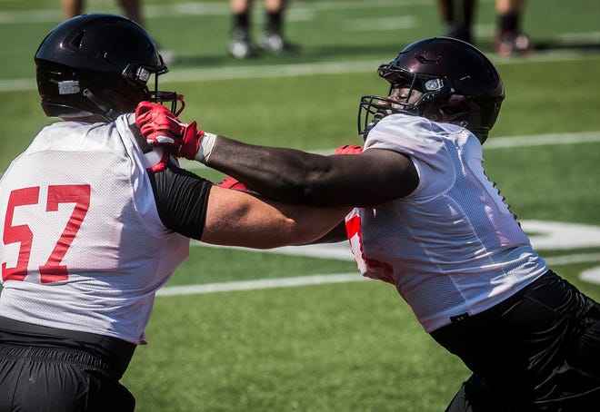 Ball State's Chris Agyemang (right) extends his arms on a blocker during Ball State football's first fall practice at Scheumann Stadium Wednesday, Aug. 4, 2021.