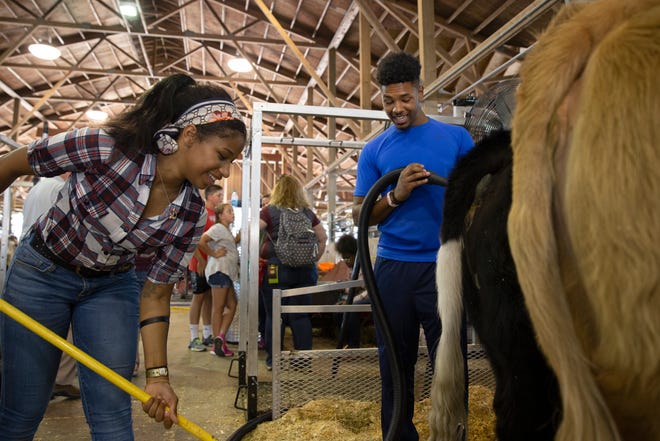 Pictured in 2019, Vincent High School students Kristine Blackwell and Brandon Albright clean up their stall at the Wisconsin State Fair. Vincent, known for its agricultural program, was recently awarded funds for a new barn and other renovations.