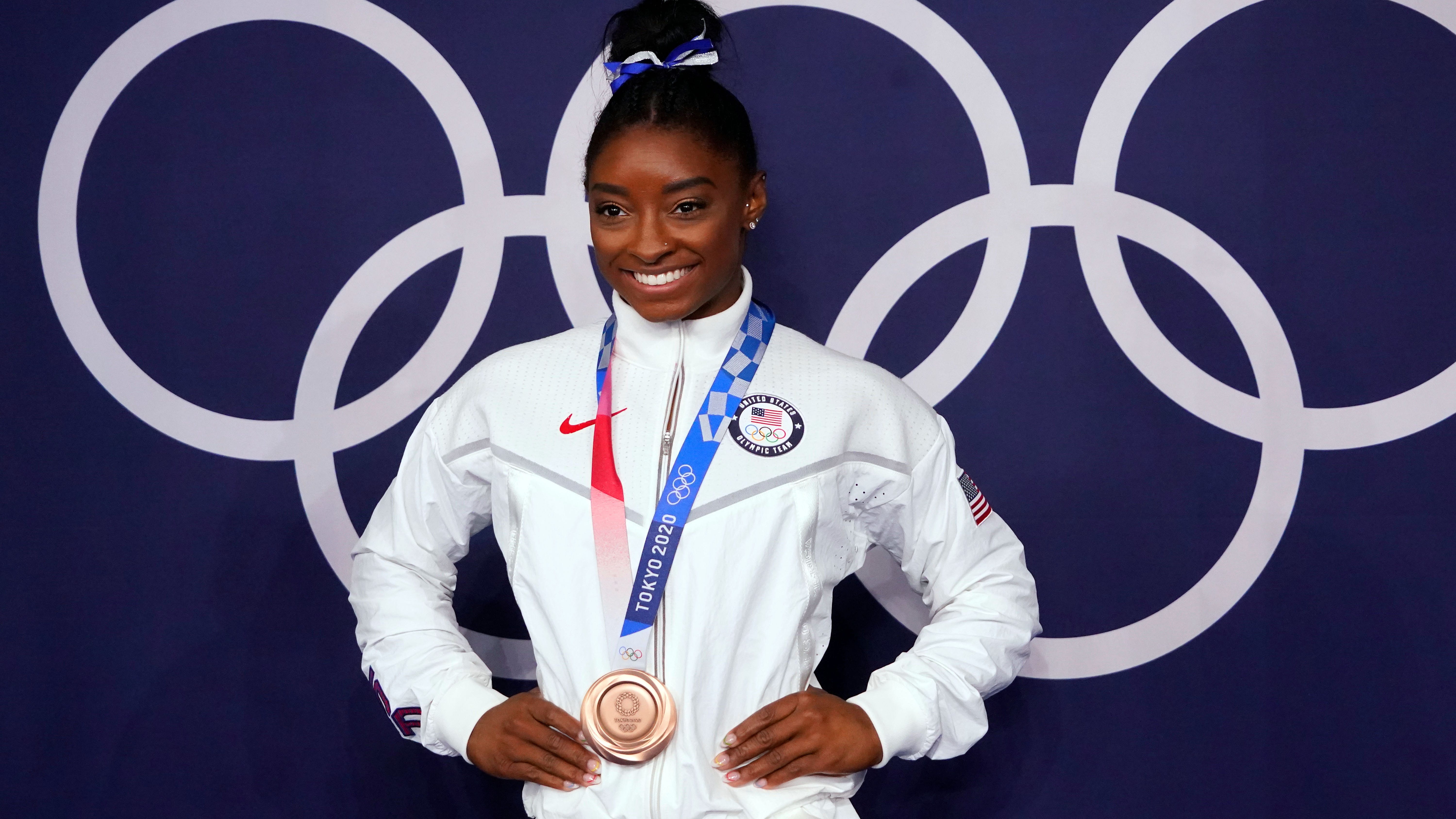 Simone Biles poses for photographs after winning the bronze medal on beam during the Tokyo 2020 Olympic Summer Games at Ariake Gymnastics Centre.