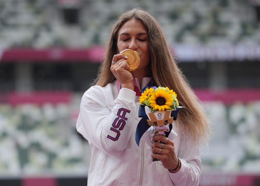 American Valarie Allman giver her new gold medal a kiss after winning the women's discus throw at the Tokyo Olympics.
