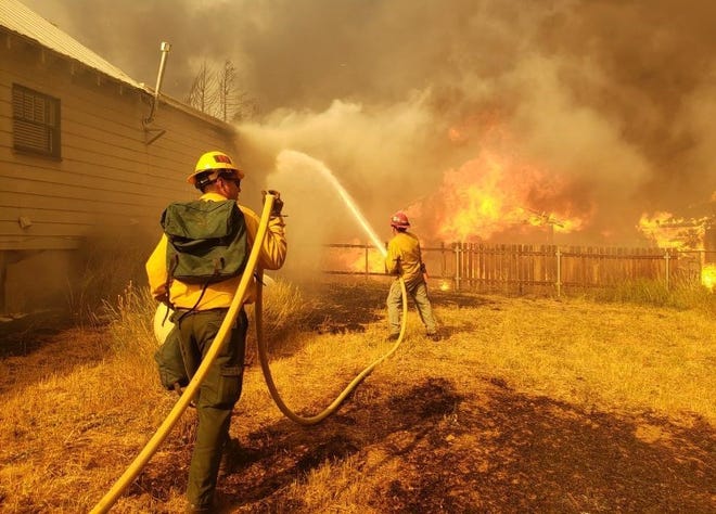 Firefighters work to protect homes in Greenville during the Dixie Fire on Thursday, Aug. 5, 2021.