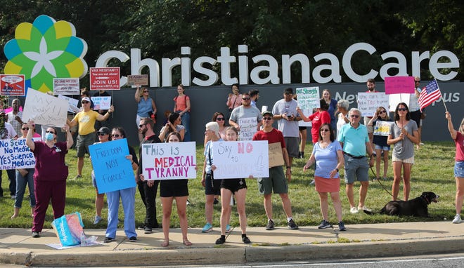 Nearly 400 protesters line the roadway in front of ChristianaCare's Christiana Hospital in a demonstration against the health care system's requirement that employees receive the COVID-19 vaccination.