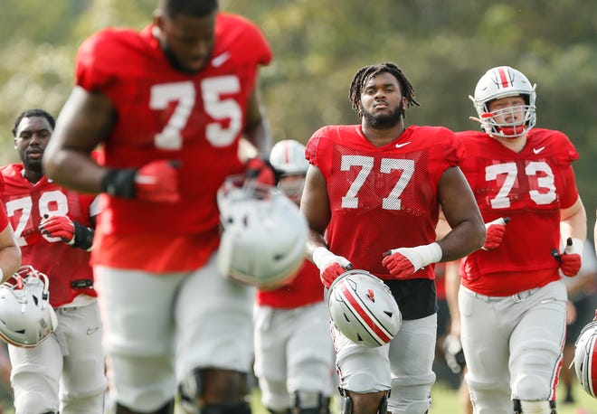 Ohio State Buckeyes offensive lineman, including Paris Johnson Jr. (77), run between drills during football training camp at the Woody Hayes Athletic Center in Columbus on Tuesday, Aug. 10, 2021. 