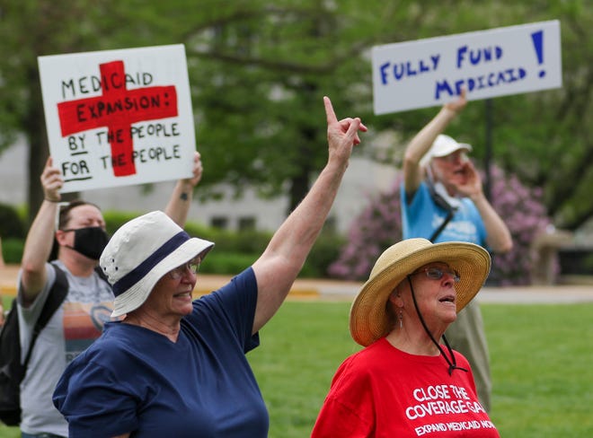 In this April 27, 2021, file photo, Maxine Horgan, left, and Barbara Nyden attend a Medicaid expansion rally at the Missouri State Capitol in Jefferson City, Mo.. A Missouri judge says Gov. Mike Parson can no longer deny Medicaid health care to thousands more newly eligible adults. Cole County Judge Jon Beetem issued the order Tuesday.