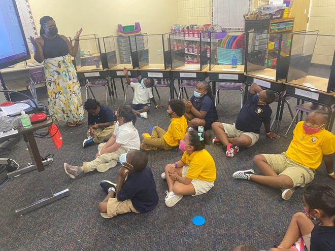 A group of masked second-grade students listen to teacher Jacquelyn Stepp at Emma E. Booker Elementary School, in Sarasota, during the first day of school Aug. 10.