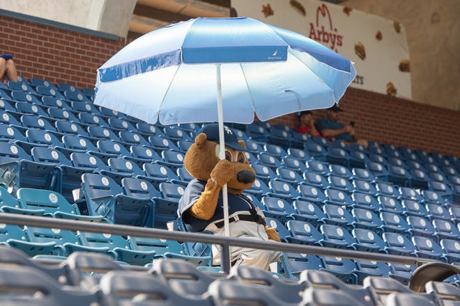 Ted E. Tourist beats the head with a large umbrella prior to a game earlier this season against Winston-Salem at McCormick Field. MAYA CARTER/ ASHEVILLE CITIZEN-TIMES