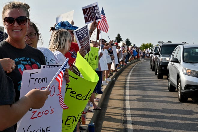 People line Thomas More Parkway by St. Elizabeth Edgewood Hospital in Edgewood, Ky on Tuesday, August 10, 2021 to protest St. Elizabeth’s newly announced COVID-19 vaccine requirement. The hospital and other medical centers have announced mandatory vaccination for all healthcare workers they employ.