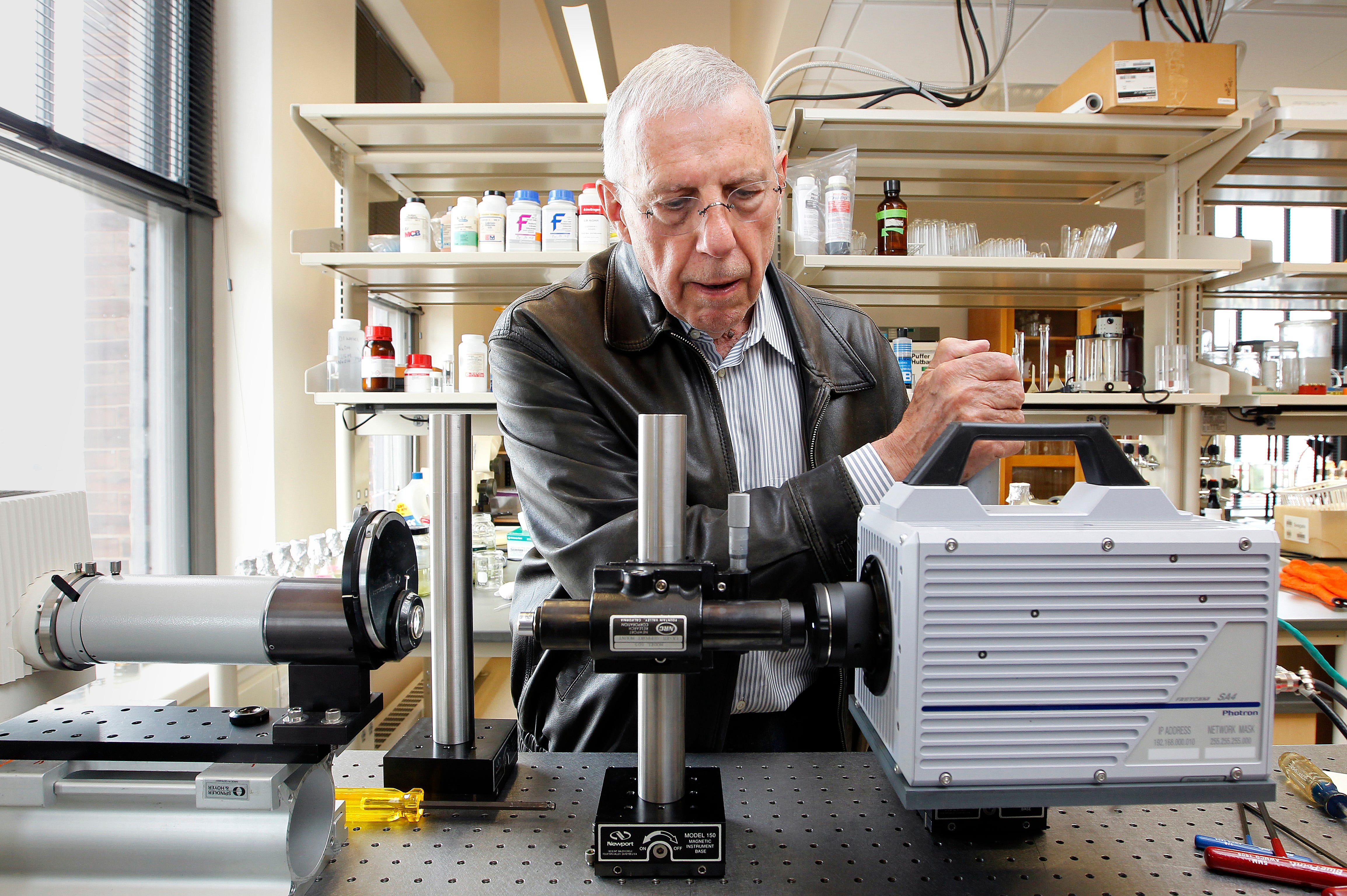 Rudi Strickler sets up a microscope that uses a concentrated beam of light to photograph exotic invasive organisms in the Great Lakes. Strickler is a researcher with the UWM Great Lakes Water Institute.