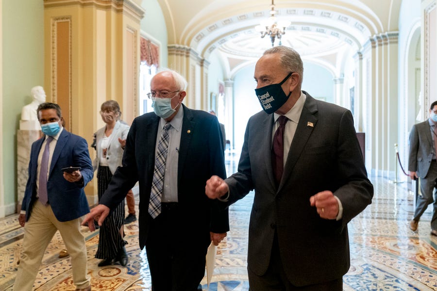 Sen. Bernie Sanders, I-Vt., left, and Senate Majority Leader Chuck Schumer of N.Y., right, speak to members of the media as they walk out of a budget resolution meeting at the Capitol in Washington, Monday, Aug. 9, 2021. (AP Photo/Andrew Harnik) ORG XMIT: DCAH114