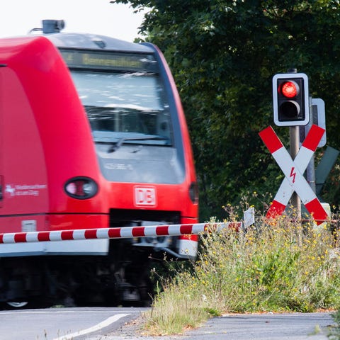 A Deutsche Bahn commuter train passes a level cros