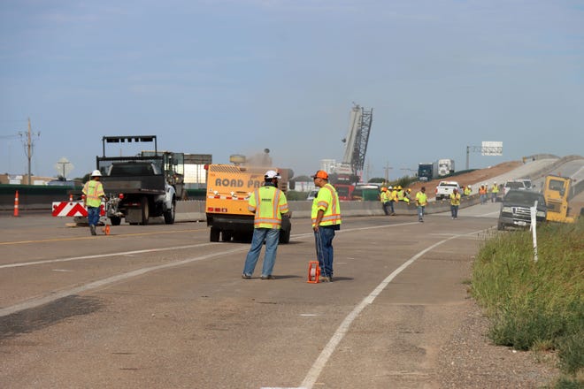 Crews work to make the west bound I-40 traffic transition to the new Helium Road overpass Wednesday.
