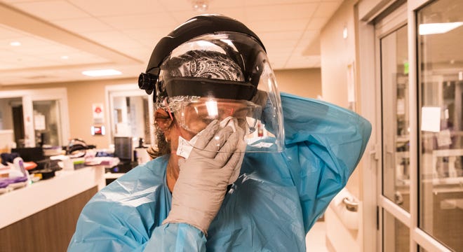 Shannon Stewart, right,  a respiratory therapist at the downtown campus of NCH in Naples adjusts her mask before treating a COVID-19 patient on Monday, August 9, 2021. 