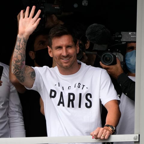 Lionel Messi waves after arriving at Le Bourget ai