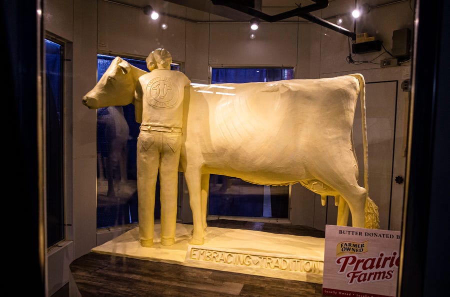 The 2021 Butter Cow by sculptor Sarah Pratt unveiled in the Dairy Building at the Illinois State Fairgrounds marks the 100th anniversary of the Butter Cow at the Illinois State Fair in Springfield, Ill., on Wednesday, August 11, 2021. The theme of this year's Butter Cow is "Embracing Tradition" and features a young exhibitor embracing the cow along with 13 hearts hidden throughout representing 13 essential nutrients found naturally in milk.