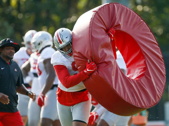 Ohio State Buckeyes defensive tackle Jacolbe Cowan (93) carries a tackling ring during football training camp at the Woody Hayes Athletic Center in Columbus on Thursday, Aug. 12, 2021. 