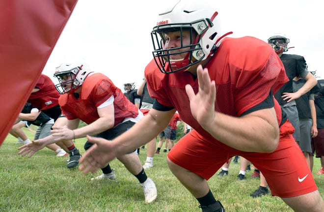 Monroe High School lineman Gavin Yount sets to drive the sled bag with his teammates during practice last week.