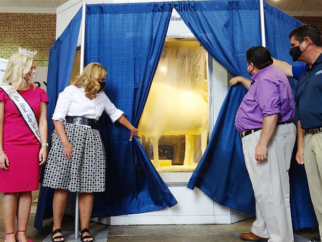 Gov. JB Pritzker and First Lady MK Pritzker unveil the Illinois State Fair's 2021 butter cow, along with Department of Agriculture Director Jerry Costello II, far right, and 2021 Miss Illinois County Fair Queen Kelsi Kessler. This year's sculpture, by artist Sarah Pratt, is entitled "Embracing Tradition." It contains 13 hidden hearts that signify the 13 essential nutrients that occur naturally in milk.