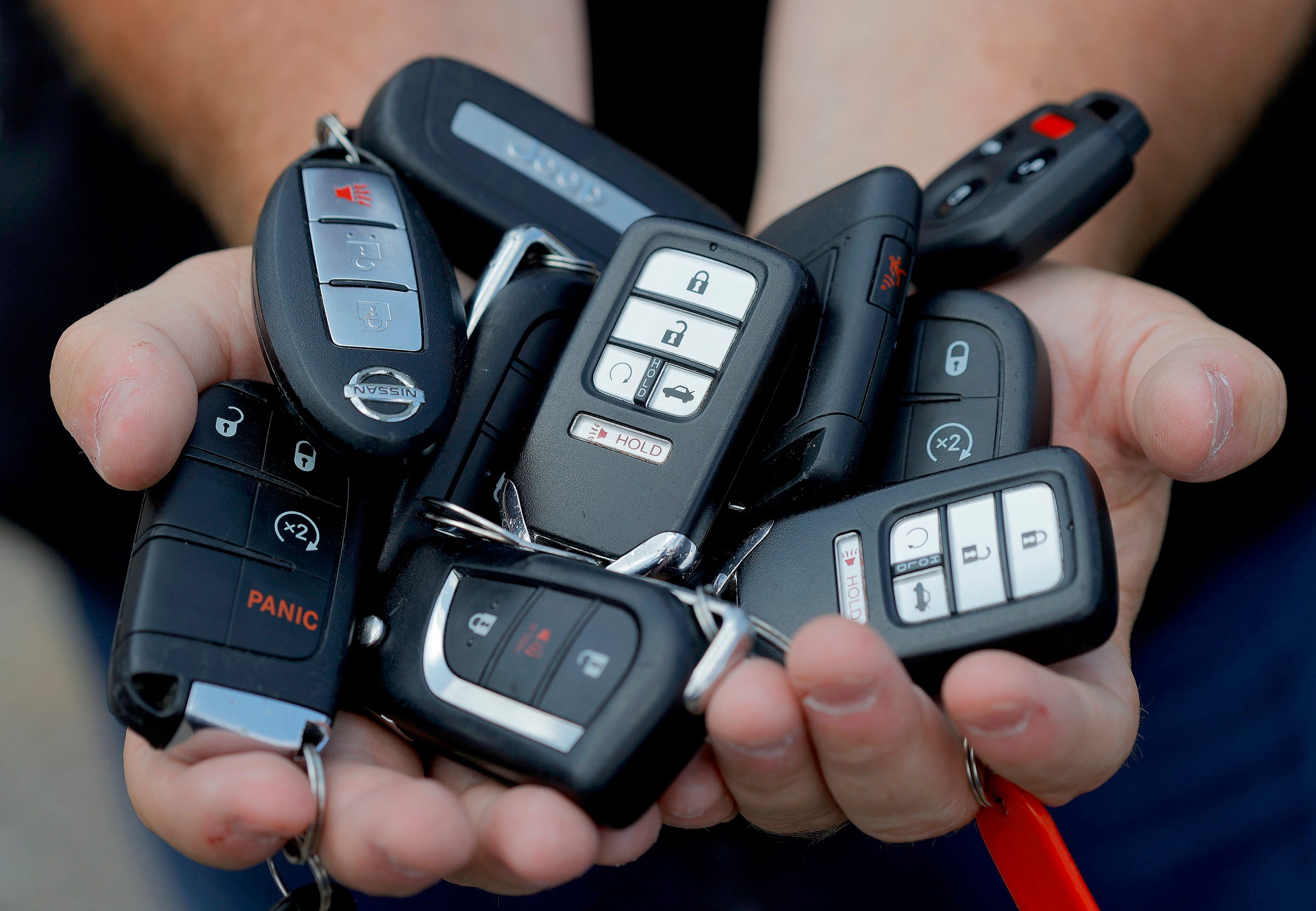 Eleven key fobs of the cars Bill Huffhine is holding at a parking lot in Troy on August 10, 2021. Huffhine started using the popular app as a side business in late 2017 and at one point had 20 cars in his fleet to rent out. More people are using Turo as an alternative to the big car rental agencies.