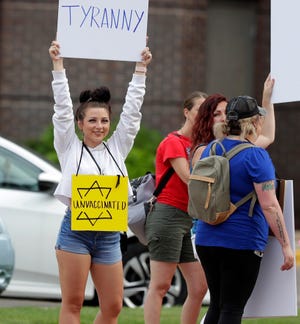 Protesters march in opposition of vaccine mandates for hospital employees outside Bellin and St. Vincent hospitals along Webster Avenue on Aug. 11, 2021, in Green Bay, Wis.