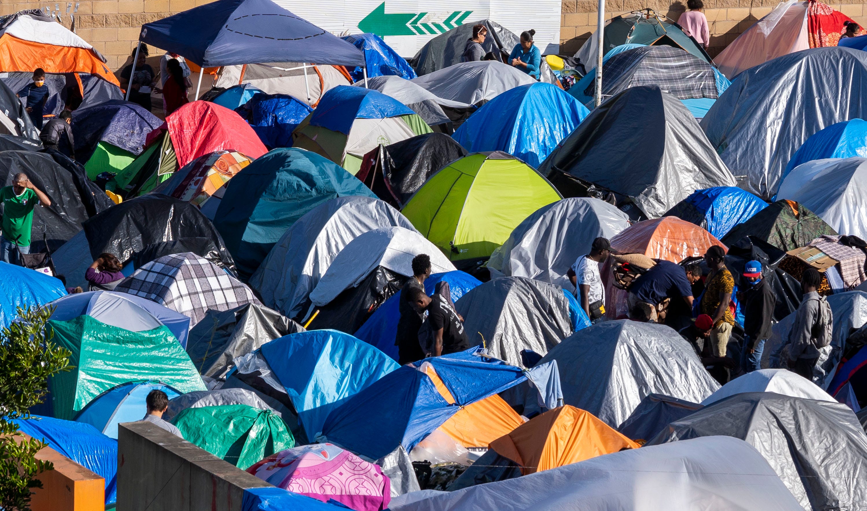 Más de 1,000 migrantes de Centroamérica y México viven en una tienda de campaña improvisada en Tijuana, en el paso fronterizo de Chaparral, frente a la frontera de San Diego. Dijeron que no se irían hasta que el gobierno de Biden comience a procesar a los solicitantes de asilo que esperan en la frontera entre Estados Unidos y México.