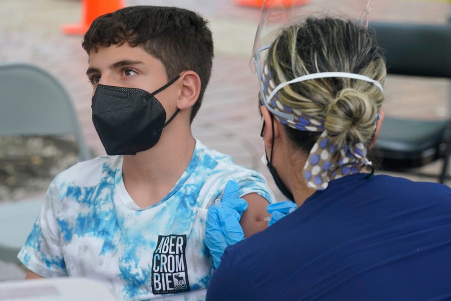 Andres Veloso, 12, gets the first dose of the Pzifer-BioNTech COVID-19 vaccine on Monday in Miami. Florida is reporting a surge of cases caused by the highly contagious delta variant.