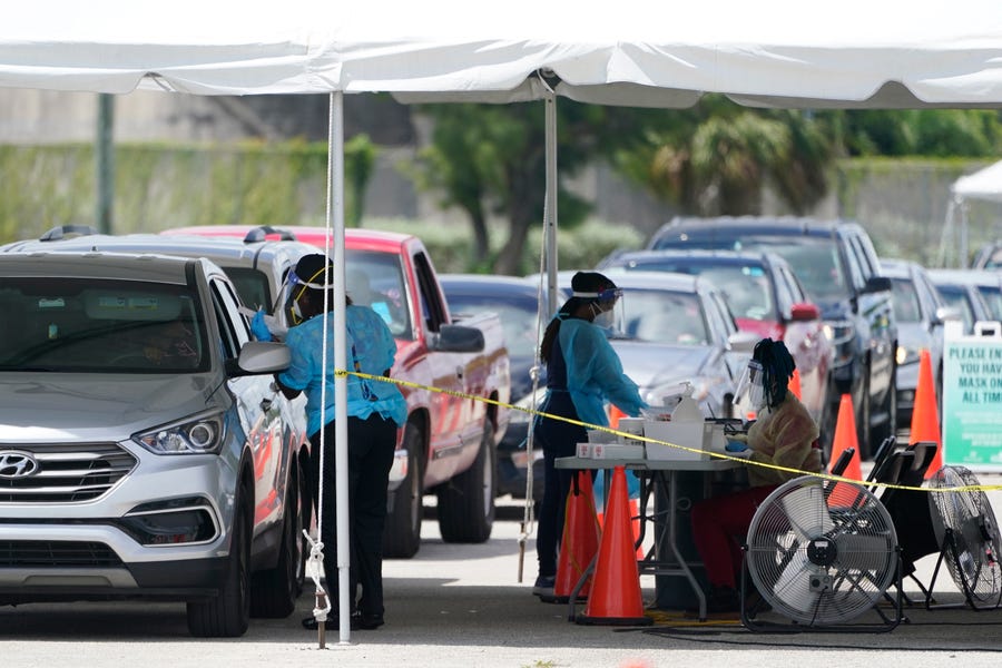 People wait in cars to get a COVID-19 test, Wednesday, Aug. 11, 2021, in Miami. COVID-19 has strained some Florida hospitals so much that ambulance services and fire departments can no longer respond as usual to every call. (AP Photo/Marta Lavandier)