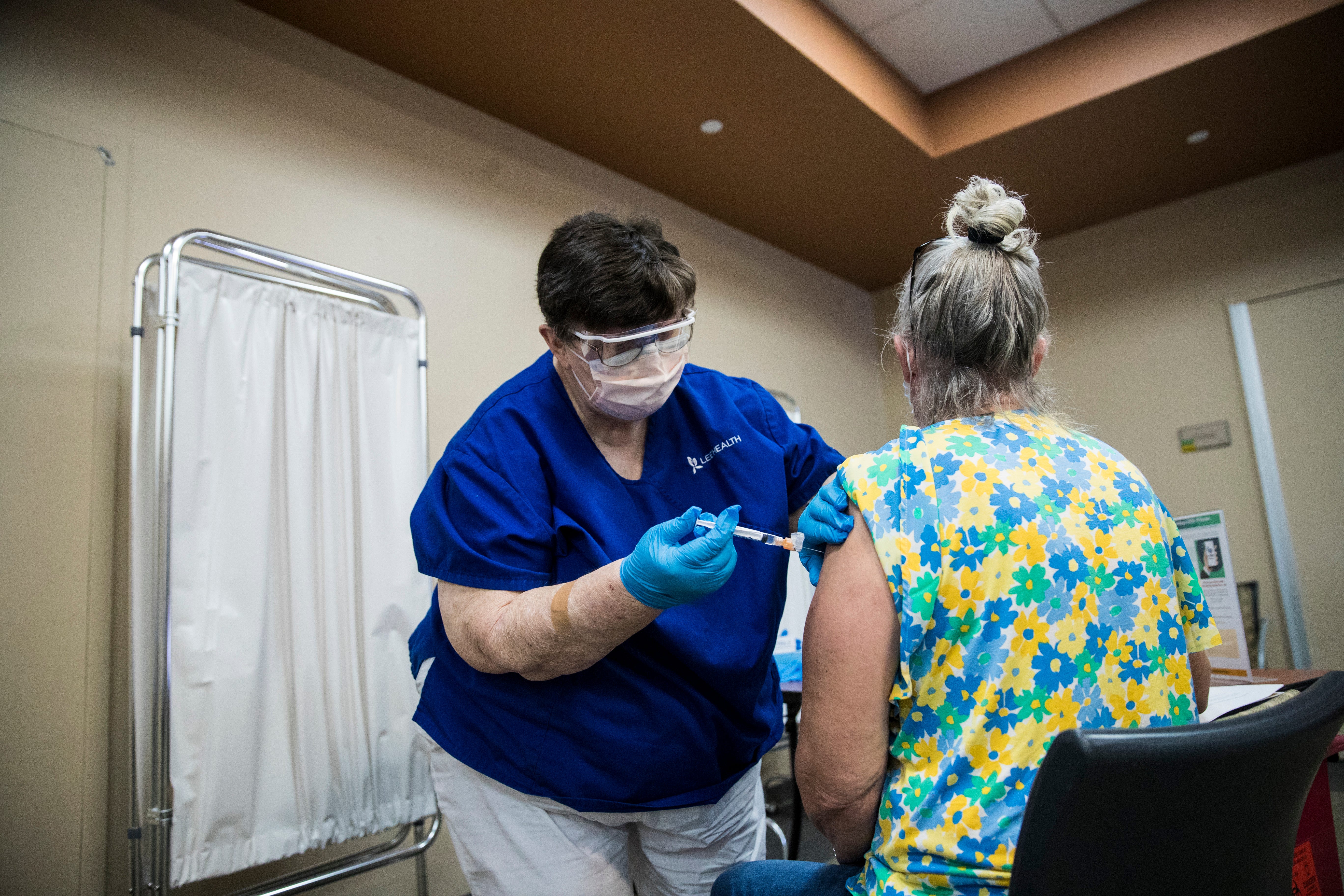 Diane Corrie, left, a registered nurse at Gulf Coast Medical Center, vaccinates Johnna Michaelkiewicz for COVID-19 at a vaccination site on the campus on Friday, Aug. 13, 2021. Vaccinations are starting to tick up as the delta variant of COVID-19 is surging.
