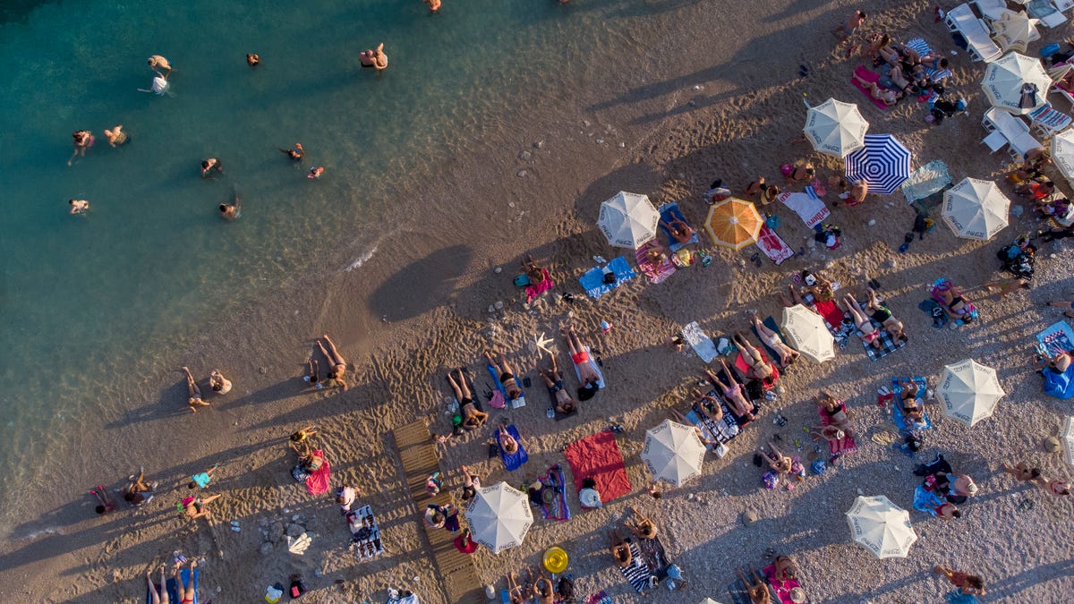Holiday makers refresh themselves in Adriatic sea in Dubrovnik, Croatia, Friday, Aug. 13, 2021. Stifling heat is gripping much of Southern Europe, with peak temperatures reaching over 40 degrees Celsius (104 degrees Fahrenheit) and forecasters saying the worse is yet to come.