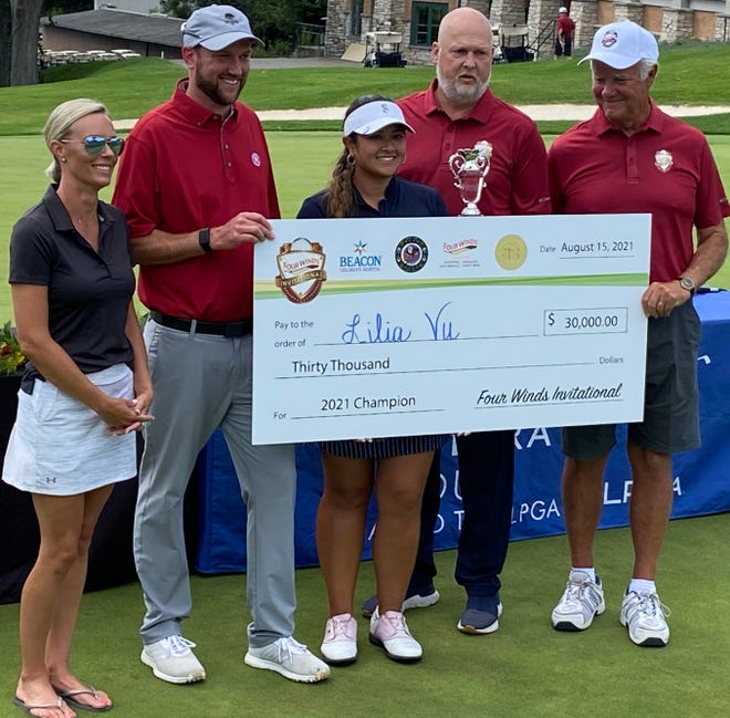 Lilia Vu, center, receives her $30,000 winner's check from tournament officials after closing with a five-under-par 67 at South Bend (Indiana) Country Club to win the Symetra Tour's Four Winds Invitational.