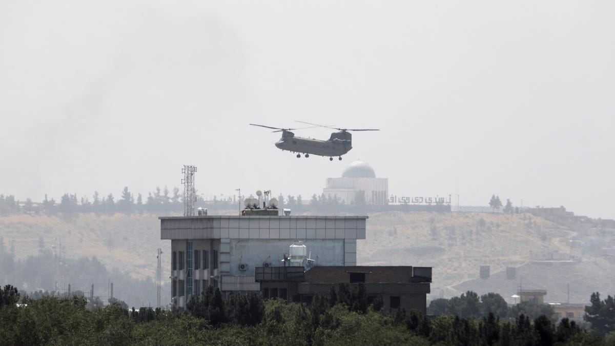 A U.S. Chinook helicopter flies near the U.S. Embassy in Kabul, Afghanistan, Sunday, Aug. 15, 2021. Helicopters are landing at the U.S. Embassy in Kabul as diplomatic vehicles leave the compound amid the Taliban advanced on the Afghan capital. 