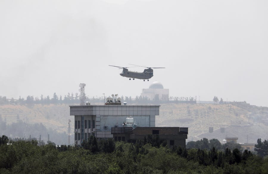 A U.S. Chinook helicopter flies near the U.S. Embassy in Kabul, Afghanistan, Sunday, Aug. 15, 2021. Helicopters are landing at the U.S. Embassy in Kabul as diplomatic vehicles leave the compound amid the Taliban advanced on the Afghan capital. 