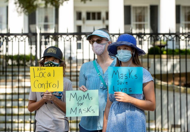 Erin Matwey, and her children Ryder Armstrong, 12, left, and Amelia Armstrong, 15, protest last month outside  the Governor’s Mansion against Gov. Greg Abbott's ban on mask mandates. Ryder and Amelia are students in Austin schools. The Legislature is considering bills regarding school mask mandates.