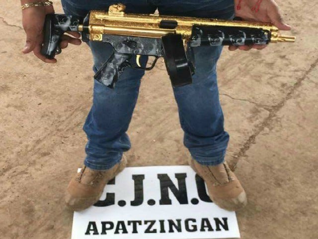 A member of the Cartel Jalisco Nueva Generacion, or CJNG, shows off a gold-plated gun in the Mexican state of Michoacan, where gun battles over turf are common between the cartel and its rivals.