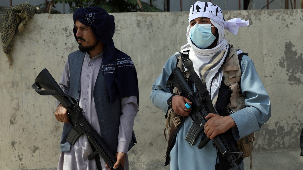 Taliban fighters stand guard in the main gate leading to Afghan presidential palace, in Kabul, Afghanistan, Monday, Aug. 16, 2021. The U.S. military struggled to manage a chaotic evacuation from Afghanistan on Monday as the Taliban patrolled the capital and tried to project calm after toppling the Western-backed government.