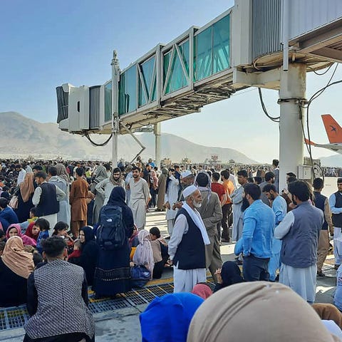 Afghans crowd at the tarmac of the Kabul airport o