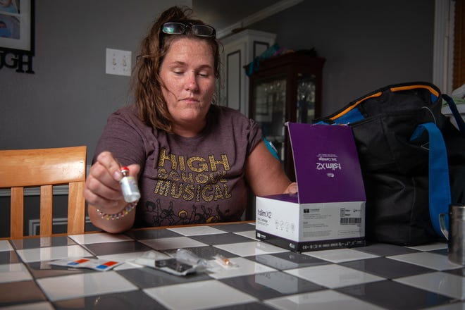 Courtney Massery exhibits her insulin and diabetes equipment inside her home in Ward, Ark., on Aug. 12, 2021.