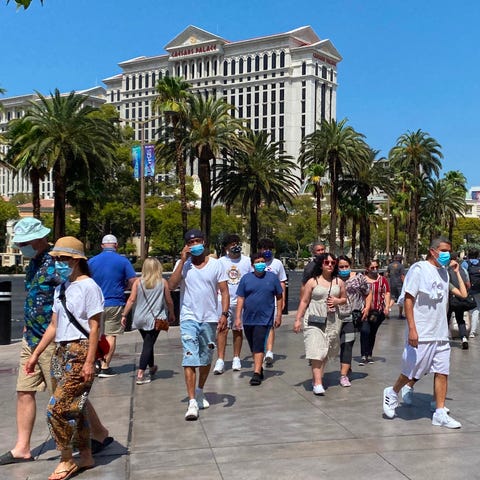 Tourists wearing masks walk on the Strip in Las Ve