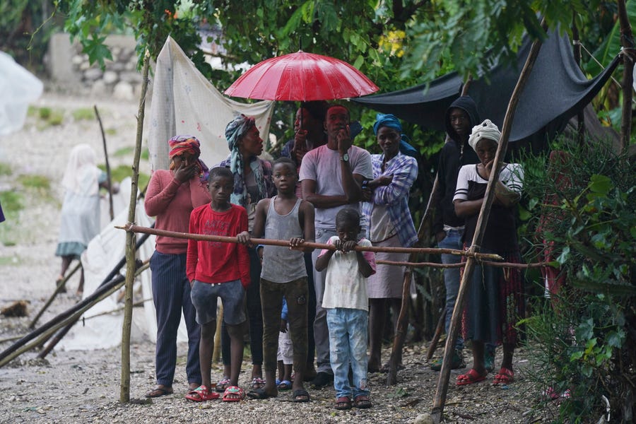 Earthquake-displaced people are exposed to the elements the morning after Tropical Storm Grace swept over Les Cayes, Haiti, Tuesday, Aug. 17, 2021, three days after a 7.2-magnitude earthquake.