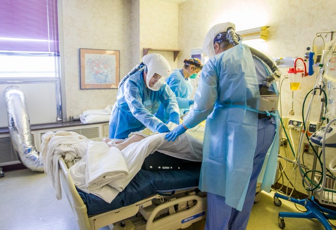 Medical staff turn a patient onto their side inside Elkhart General Hospital's COVID-19 unit in this January 2021 file photo. Across the country, and locally, hospitals are reporting being increasingly short staffed, putting even more pressure on capacity in the midst of the coronavirus pandemic.